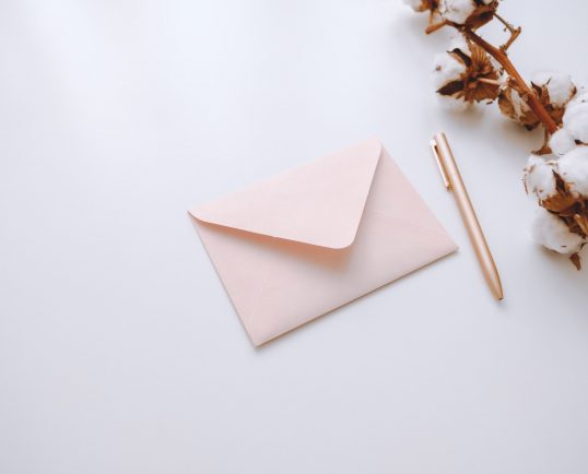 pink-envelope-with-pen-on-a-white-background-with-a-cotton-branch.jpg